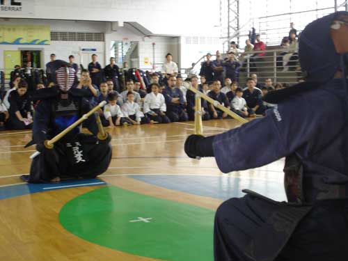 Kendoka performing sonkyo before keiko with spectators watching